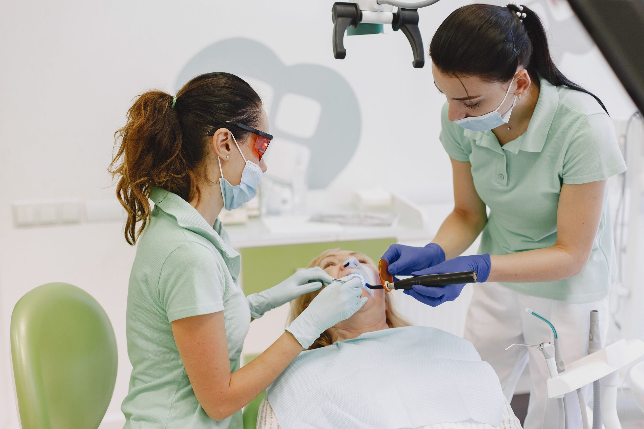 Our Services Dentists performing a dental procedure on a patient in a contemporary clinic.