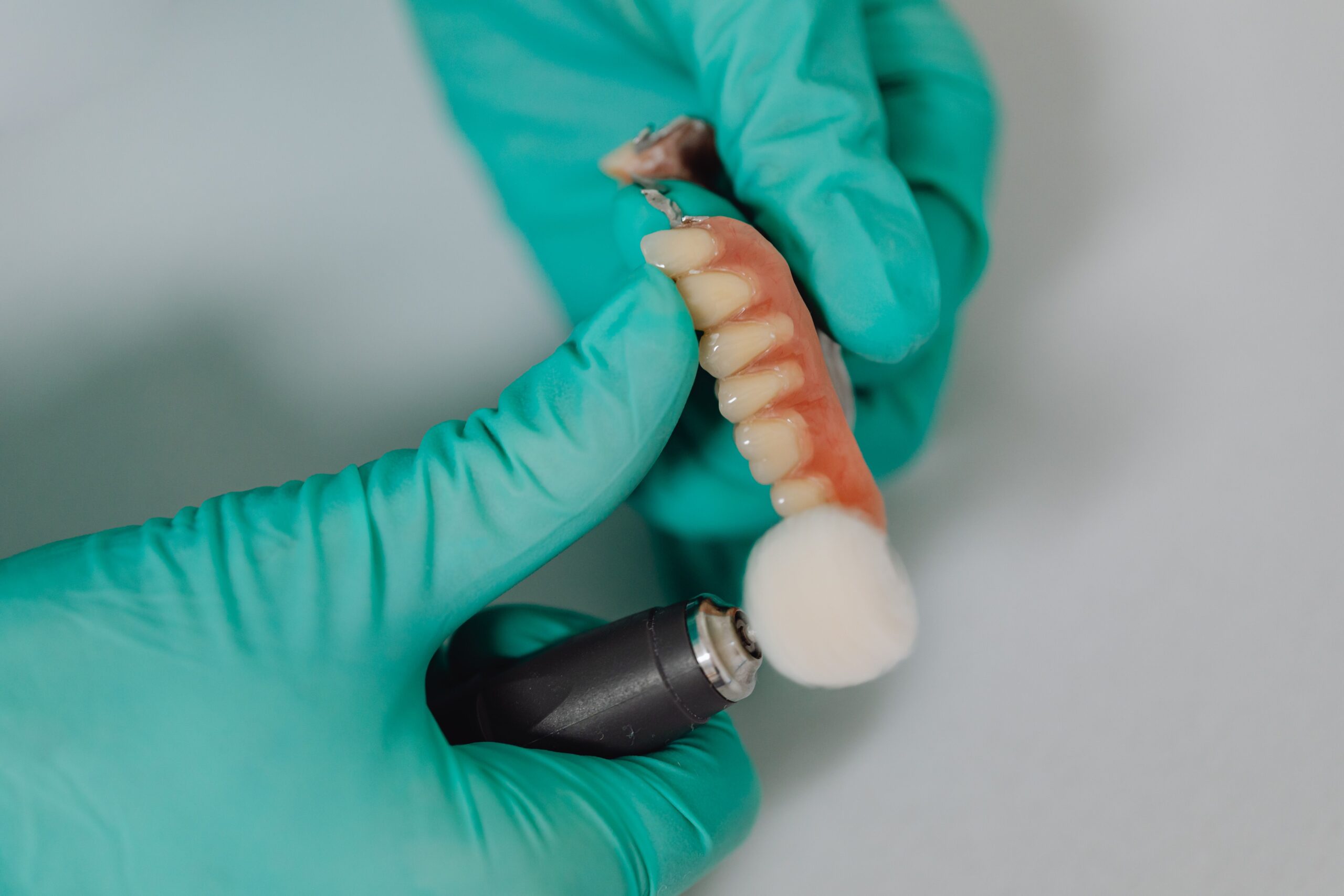 Our Services Detailed view of a dentist polishing dental implants with precision, showcasing professional dental care.